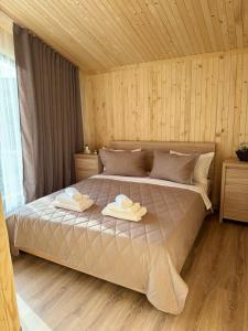 a bedroom with a bed with two towels on it at Forest Solotvyno in Solotvyno +23 photos