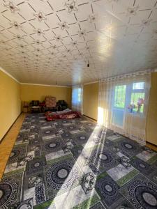 a living room with a large rug on the floor at Bloom Guest House in Tërt-Kul'