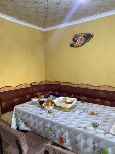a table with plates of food on top of it at Bloom Guest House in Tërt-Kul'