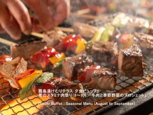 a plate of food with meat and vegetables on a grill at Kirishima Kokusai Hotel in Kirishima