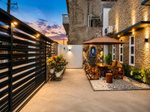 a patio with a wooden fence and a table with an umbrella at Zenith Haven Casa de Padrillos in Imus
