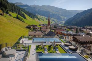a resort with a view of a town and a church at Aktiv- & Wellnesshotel Bergfried in Tux