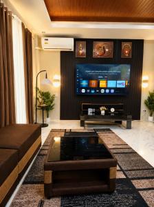 a living room with a couch and a tv at Zenith Haven Casa de Padrillos in Imus