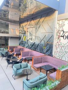 a lobby with purple couches and tables and a mural at Nathivian Apartment in Mobushipe