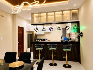 a kitchen with a table and chairs and a bar at Zenith Haven Casa de Padrillos in Imus