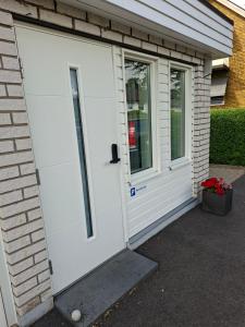 a white garage door on a house with a window at Boende i Falkenberg in Falkenberg +2 photos