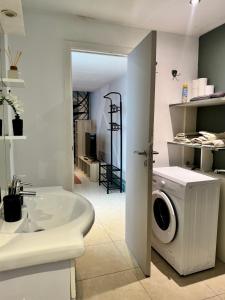 a bathroom with a washing machine and a tub at Yamohome in Brussels