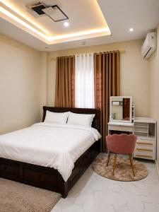 a bedroom with a bed and a tv and a chair at Zenith Haven Casa de Padrillos in Imus +19 photos