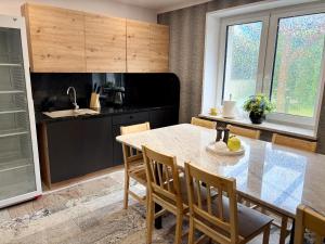a kitchen with a table and chairs and a sink at Perła Chmielna in Chmielno
