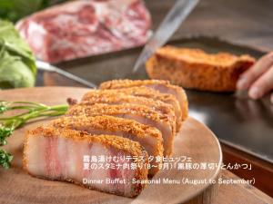 a piece of meat on a cutting board with bread at Kirishima Kokusai Hotel in Kirishima