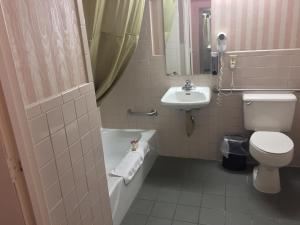 a bathroom with a toilet and a tub and a sink at Americas Best Value Inn & Suites-Boise in Boise