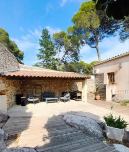 a patio at a house with a tree at domaine de bessilles in Montagnac