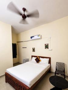 a bedroom with a bed with a ceiling fan at Hotel Far-Inn in Irungattukottai