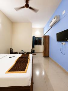 a bedroom with a bed and a ceiling fan at Hotel Far-Inn in Irungattukottai +16 photos