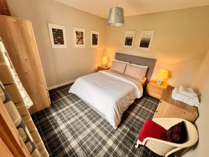 a small bedroom with a bed and a chair at Taigh Tuaram in Carloway