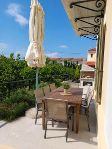a table and chairs and an umbrella on a patio at Valimitika beach house - Just 150m from the beach in Valimítika