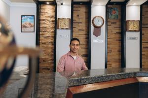 a man standing in a room with clocks on the walls at Fantasia Hotel in Hurghada