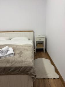a bedroom with a bed and a table with a rug at Aero Comfort Apartment in Cluj-Napoca