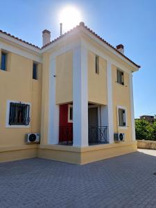 a large yellow building with a red door at Valimitika beach house - Just 150m from the beach in Valimítika