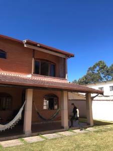 a man is running out of a house at Chácara com Piscina in Poços de Caldas
