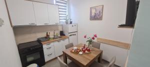 a small kitchen with a small table and a small kitchen with a sink at Sabina Apartmani in Tuzla