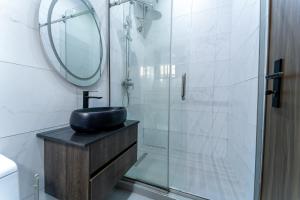 a bathroom with a sink and a shower with a mirror at One90 Apartment in Lagos +104 photos