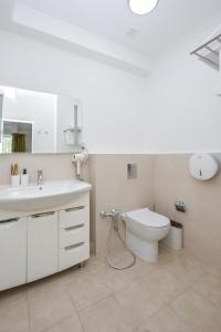 a white bathroom with a sink and a toilet at Hotel Astoria, в самом центре города in Astana
