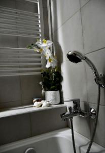 a bathroom with a bath tub with a vase with flowers at Kyma&Soul Seaview Loft in Xylokastro +28 photos