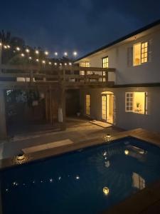 a swimming pool in front of a house at night at Casa Bali Tropical Escape in Vega Alta