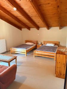 two beds in a room with wooden ceilings at Sonya Apartments in Mesochórion