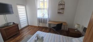 a room with a desk and a television and a table at Sabina Apartmani in Tuzla