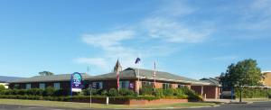 a building with two flags in front of it at Ararat Southern Cross Motor Inn in Ararat