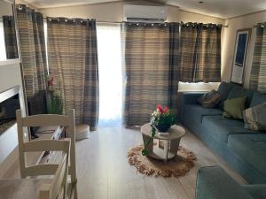 a living room with a blue couch and a table at Mon nid douillet in Valras-Plage