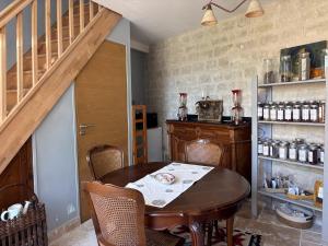a dining room with a wooden table and a staircase at Grange d'époque à Chantilly in Chantilly