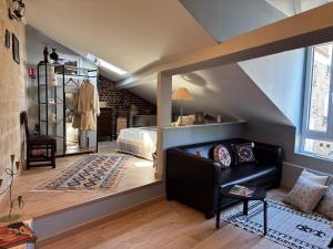 a attic bedroom with a bed and a couch in a room at Grange d'époque à Chantilly in Chantilly