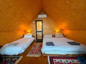 two twin beds in a room with a wall at Strofka in Maliq
