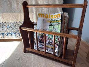 a wooden magazine rack with a newspaper at Grange d'époque à Chantilly in Chantilly