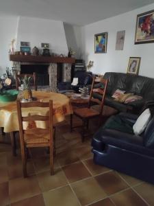a living room with a couch and a table at Chez Danielle in Saint-Georges-de-Baroille