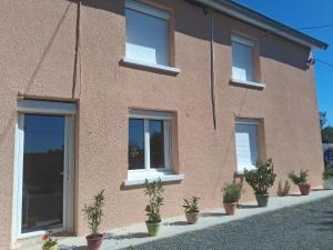 a brick building with potted plants in front of it at Chez Danielle in Saint-Georges-de-Baroille