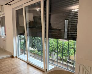 a room with sliding glass doors with a balcony at Aero Comfort Apartment in Cluj-Napoca