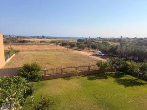 a yard with a fence and a field of grass at Sonya Apartments in Mesochórion +3 photos
