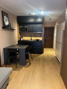 a kitchen with a table and a sink and a refrigerator at FREE PARKING - Edilneve Apartment in Roccaraso