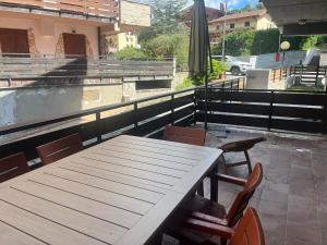 a wooden table and chairs on a patio at FREE PARKING - Edilneve Apartment in Roccaraso