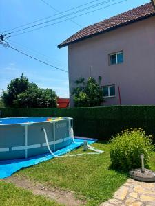 a swimming pool with a hose connected to a house at APARTMAN BAMBUS in Lug