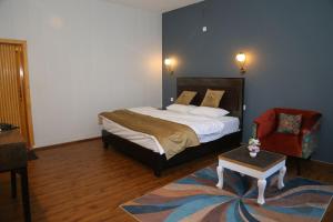 a bedroom with a bed and a chair and a table at Hunza Oriole Hotel in Alīābād