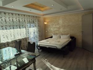 a bedroom with a bed and a glass table at Eligo in Friedrichshafen