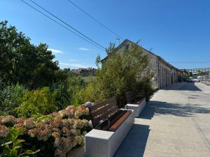 two benches sitting on a sidewalk next to some bushes at Border Bridge House in Tui