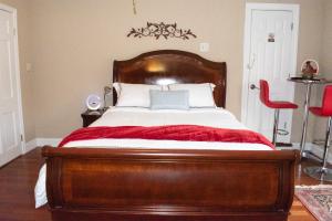 a bedroom with a wooden bed with a red chair at National Harbor Suite 2 in Fort Washington