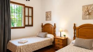 a bedroom with two beds and a window at Villa La Clavelina Rocabella in El Chorro