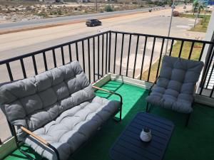 a balcony with a couch and two chairs and a table at Appartement sur Mer in El Arba de Trougout